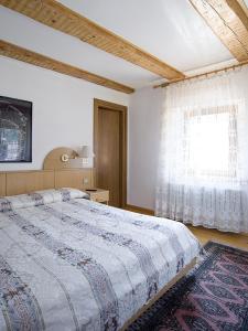 una camera da letto con un letto grande e una finestra di Hotel Erika ad Auronzo di Cadore Altre 21 foto