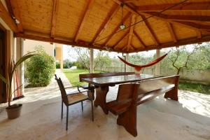a wooden table and chairs sitting under a roof at Villa Zvizda in Zadar