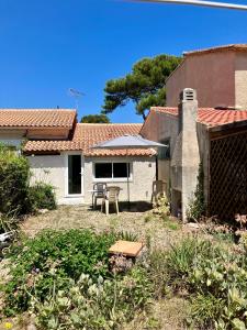 une cour avec une maison dotée d'une table et d'une terrasse dans l'établissement Maison bord de mer, à Hyères