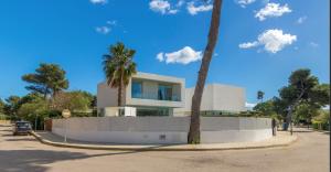 una casa con palmeras delante en Villa Pau, en Playa de Muro