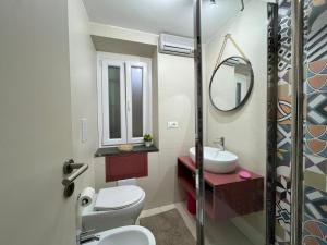 ein Badezimmer mit Toilette, Waschbecken und Spiegel in der Unterkunft iMinerva Garden Panoramic Suite in Salerno + 9 Fotos