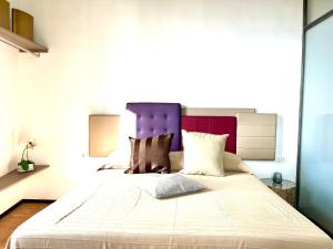 ein Schlafzimmer mit einem großen Bett mit einem lila Kopfteil in der Unterkunft iMinerva Garden Panoramic Suite in Salerno