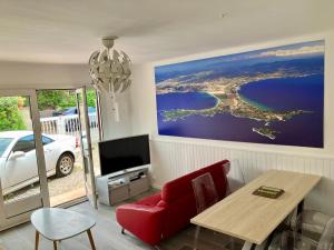 a living room with a red couch and a table at Maison bord de mer in Hyères