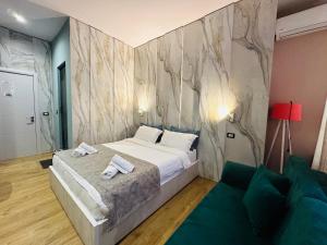 a bedroom with a bed and a couch at Colombia Apartments&Rooms in Durrës