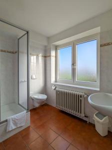 ein Badezimmer mit Dusche, Waschbecken und Toilette in der Unterkunft Gästehaus Bleckmar in Bergen