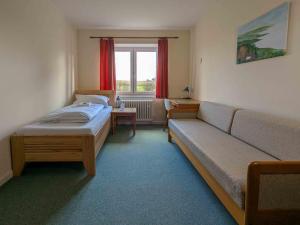 Zimmer mit Sofa, Bett und Fenster in der Unterkunft Gästehaus Bleckmar in Bergen + 27 Fotos