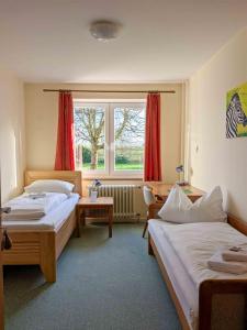 ein Schlafzimmer mit zwei Betten und einem Fenster in der Unterkunft Gästehaus Bleckmar in Bergen