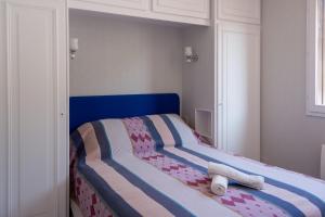 een bed met een blauw hoofdeinde in een slaapkamer bij Les Reflets de la Houle in Cancale