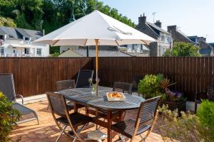 een tafel met een parasol op een terras bij Les Reflets de la Houle in Cancale