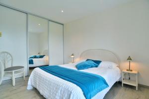 a bedroom with a large bed with a blue blanket at Gîte Radegonde in Saint-Méloir-des-Ondes