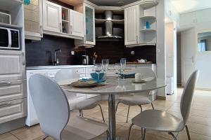 a kitchen with a table and chairs in a kitchen at Le petit chalet bleu in Cancale