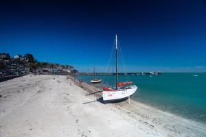 a boat sitting on the shore of a beach at Le petit chalet bleu in Cancale