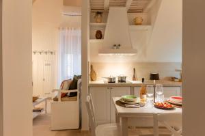 eine weiße Küche mit einem Tisch mit Tellern und Weingläsern in der Unterkunft Le Antiche Volte in Fasano + 55 Fotos