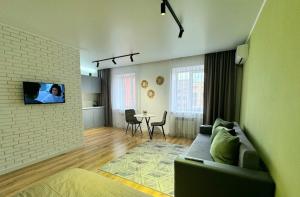 a living room with a couch and a tv on a wall at Jenis in Kokshetau