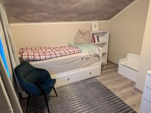 una piccola camera da letto con un letto e una sedia di Villa Borealis a Trondalen