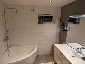 un bagno con vasca e lavandino di Villa Borealis a Trondalen Altre 15 foto