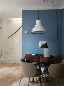 a dining room with a blue wall and a table with chairs at Cottage at Sea in Noordwijk aan Zee