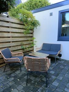 two chairs and a table on a patio at Cottage at Sea in Noordwijk aan Zee