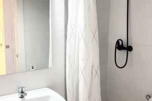 a bathroom with a shower curtain and a sink at Modern house with sea view in La Manga del Mar Menor in San Javier +15 photos