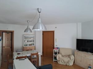 a living room with a dining table and a television at Serenità in centro città in Senigallia