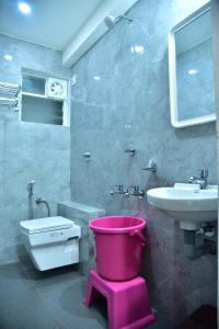 马迪凯里Coorg Balaji Palace Homestay Madikeri的浴室设有水槽旁的粉红色桶 更多35张照片