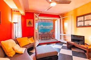 a living room with a couch and a television at Appartamento Vista Mare - Spriano in Rio Marina