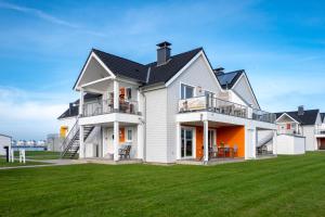 een groot wit huis met een zwart dak bij Fewo Meerwert by Seeblick Ferien in Kappeln