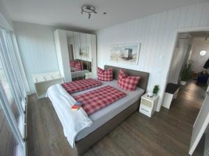 a bedroom with a large bed with red pillows at Antares One by Seeblick Ferien in Olpenitz