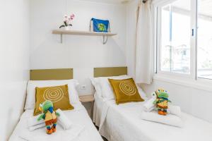 two twin beds in a room with a window at Club del Sole Riccione Easy Camping Village in Riccione