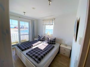 a bedroom with a bed with a view of the ocean at Strand Hus by Seeblick Ferien in Olpenitz