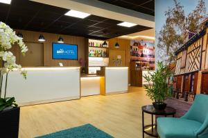 TV a/nebo společenská místnost v ubytování Brit Hotel Confort Amiens