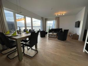 a dining room and living room with a table and chairs at Brigantine 33 by Seeblick Ferien in Olpenitz