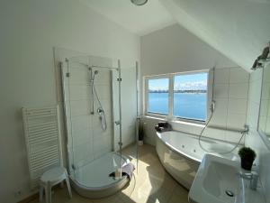 オルペニッツにあるKapteins Lounge by Seeblick Ferienの浴槽、シャワー、洗面台を備えたバスルーム +16枚の写真