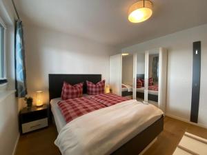 Un dormitorio con una cama grande con almohadas rojas. en Reeders Nest by Seeblick Ferien, en Olpenitz