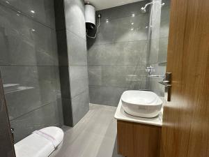 a bathroom with a toilet and a glass shower at Hotel Sky Way Inn in Hisār +10 photos
