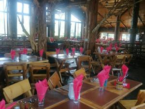 a restaurant with wooden tables with pink napkins on them at Club Vila Bran in Bran