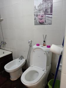 a bathroom with a white toilet and a sink at Frank spaces in Abu Dhabi
