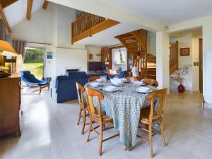 a dining room and living room with a table and chairs at Grande maison spacieuse et moderne avec jardin in Fouesnant