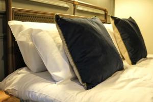 a bed with black and white pillows on it at The Willow - Studio 28 in Bristol +2 photos