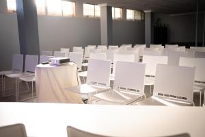 a room filled with white chairs and tables and windows at NURA Boreal in Playa de Palma +44 photos