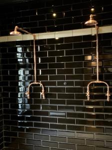 a bathroom with two lights on a brick wall at The Black House in Robertson +38 photos