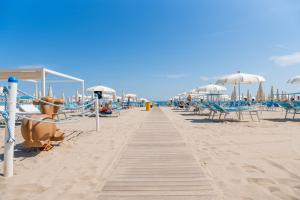 a sandy beach with chairs and umbrellas at Club del Sole Riccione Easy Camping Village in Riccione