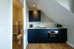 a kitchen with a sink and a toilet in a room at The Willow Apartments in Bristol