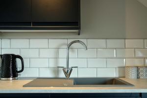 a kitchen sink with a faucet on a counter at The Willow - Studio 23 in Bristol