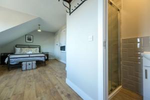 a bedroom with a bed and a walk in shower at The Willow - Studio 23 in Bristol