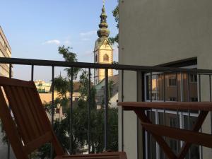 a view from the balcony of a building with a clock tower at Das Quartier in Klagenfurt