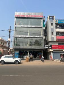 a white car parked in front of a building at Hotel Shri Ram Palace in Vidisha