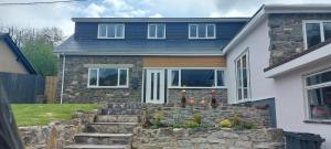 a house with a stone retaining wall in front of it at The Pantry in Erwood