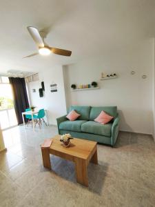 a living room with a green couch and a table at Apartamento Aguila in Benalmádena
