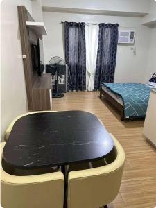 a room with a table and a bed in it at Tulip Garden Apricot Southwoods Binan 1BR with Pool & gym in Biñan